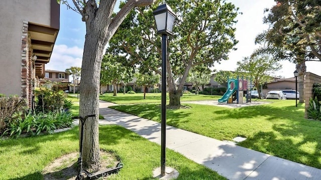 view of property's community featuring a yard and playground community