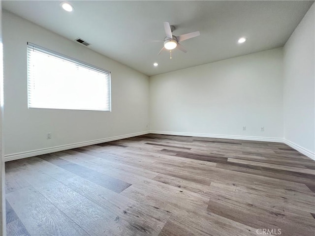 spare room with ceiling fan, visible vents, wood finished floors, baseboards, and recessed lighting