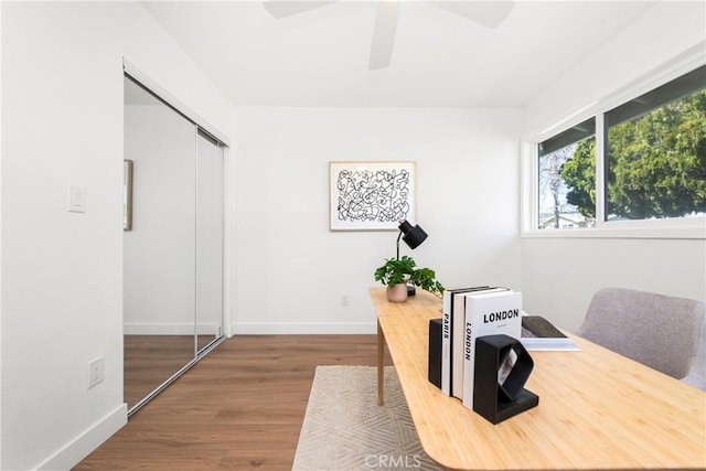 office space with baseboards, wood finished floors, and ceiling fan