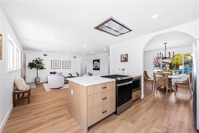 kitchen featuring modern cabinets, stainless steel appliances, light brown cabinets, and arched walkways