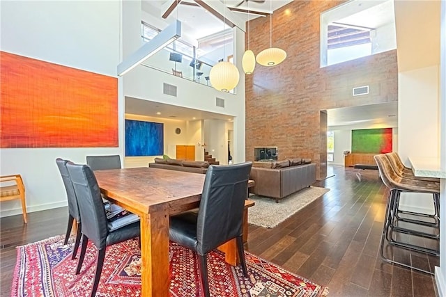 712 Orange Grove Ter, South Pasadena, CA 91030 - dining space with a towering ceiling, dark wood-style floors, a multi sided fireplace, and baseboards