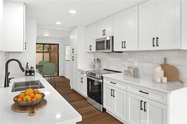 kitchen featuring light countertops, white cabinetry, stainless steel appliances, and a sink