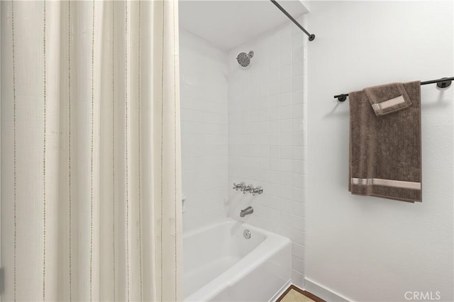 bathroom with shower / bathing tub combination and baseboards