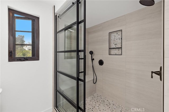 bathroom featuring baseboards and a tile shower