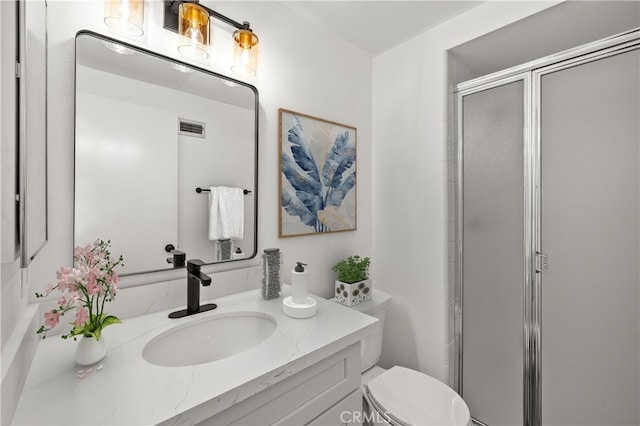 full bathroom with vanity, visible vents, a shower stall, and toilet