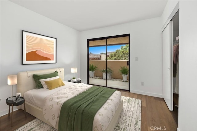 bedroom featuring baseboards, wood finished floors, and access to exterior