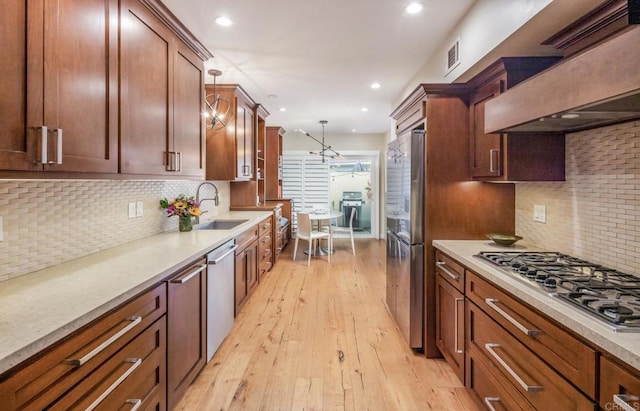 7031 Estrella De Mar Rd, Carlsbad, CA 92009 - kitchen featuring a sink, stainless steel appliances, premium range hood, decorative backsplash, and light wood finished floors