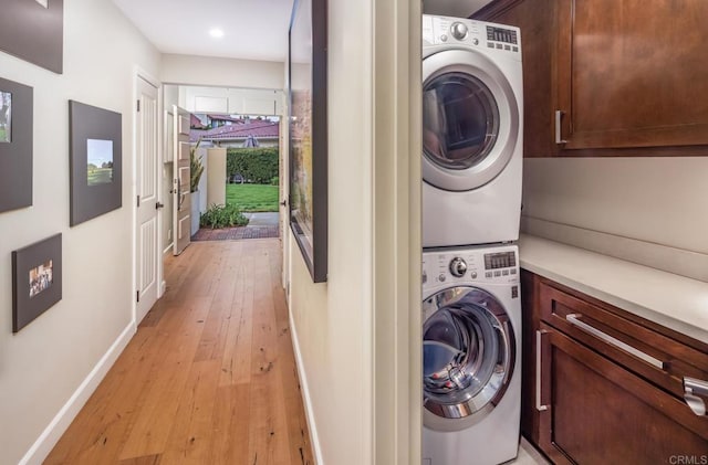 7031 Estrella De Mar Rd, Carlsbad, CA 92009 - washroom featuring stacked washing machine and dryer, cabinet space, baseboards, light wood-style floors, and recessed lighting