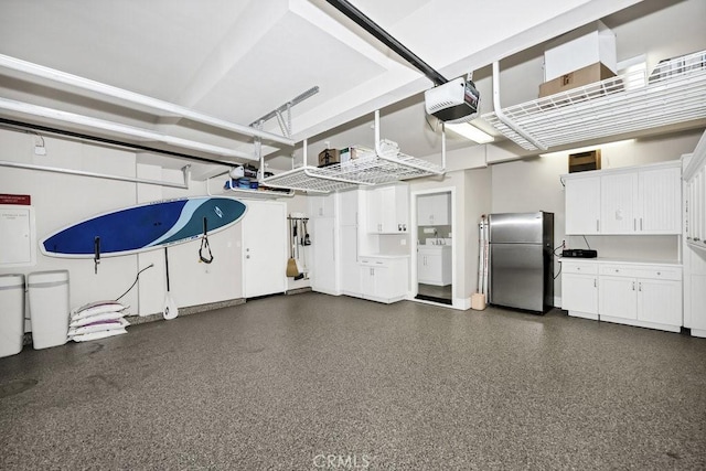 garage featuring freestanding refrigerator, a garage door opener, and washer / clothes dryer