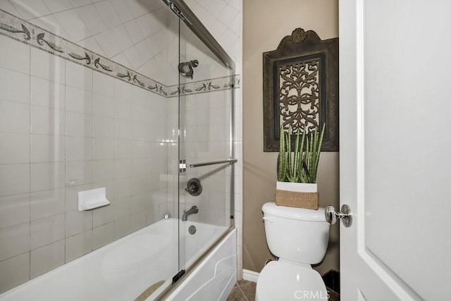 bathroom with baseboards, enclosed tub / shower combo, and toilet