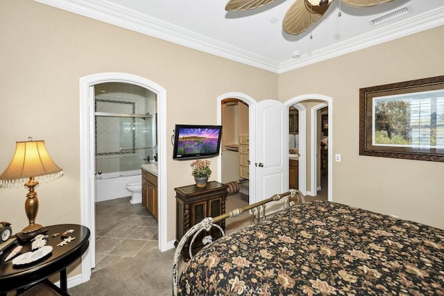 bedroom featuring visible vents, light tile patterned floors, ensuite bath, crown molding, and baseboards