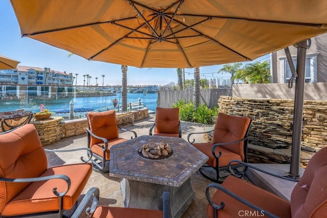 view of patio / terrace with fence and a water view