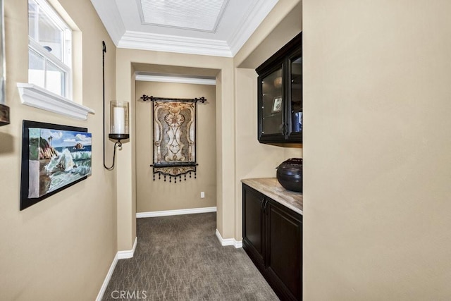 hall featuring baseboards, ornamental molding, dark colored carpet, and visible vents