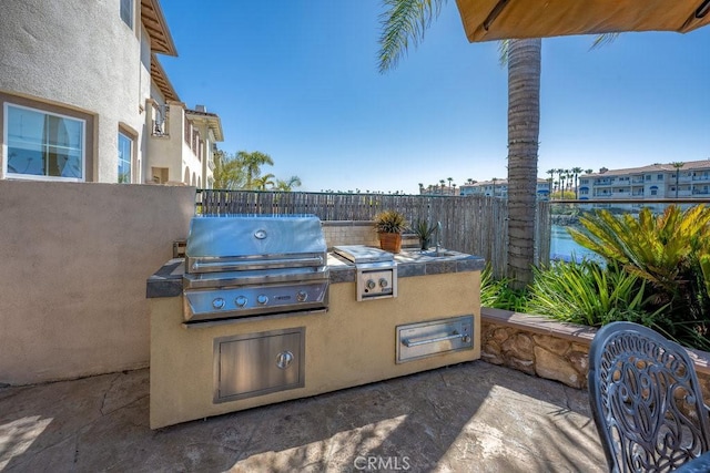 view of patio / terrace with fence, exterior kitchen, and area for grilling
