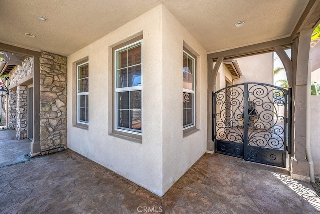 view of exterior entry with stone siding and stucco siding