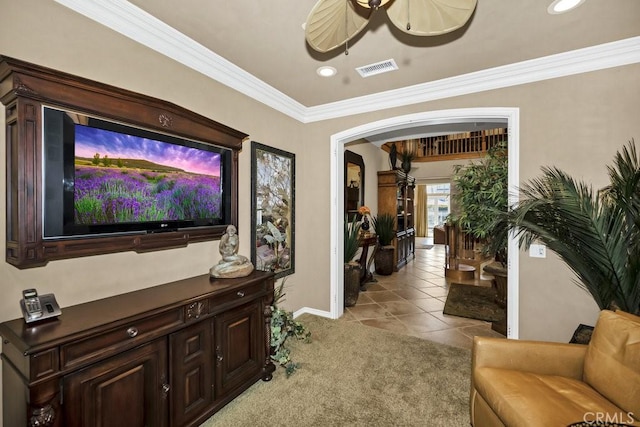 living room featuring arched walkways, light tile patterned flooring, visible vents, baseboards, and ornamental molding