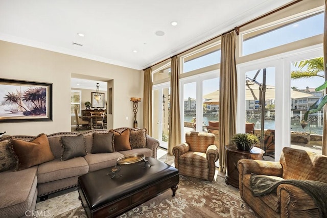 living area featuring recessed lighting, a water view, and crown molding