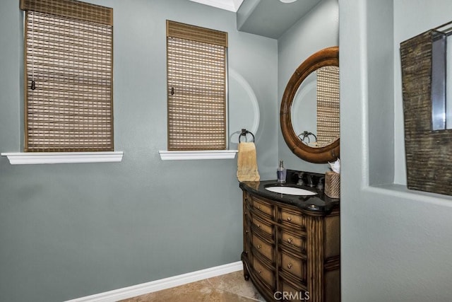 bathroom with vanity, tile patterned flooring, and baseboards