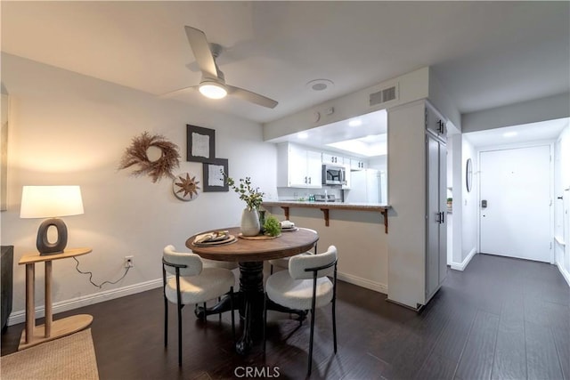 dining room featuring a ceiling fan, baseboards, dark wood-style floors, and visible vents