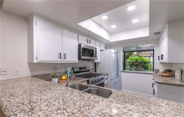 kitchen with visible vents, a raised ceiling, appliances with stainless steel finishes, white cabinetry, and recessed lighting