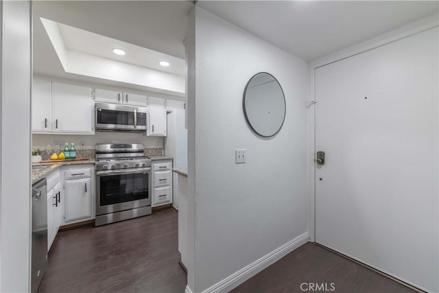 kitchen with baseboards, light stone counters, recessed lighting, white cabinetry, and appliances with stainless steel finishes