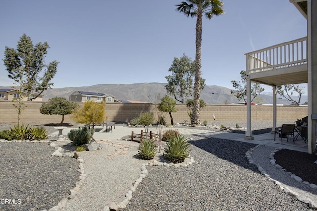 view of yard with a patio, a mountain view, and a fenced backyard