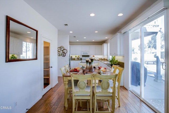 dining area with baseboards, visible vents, light wood-style floors, and recessed lighting