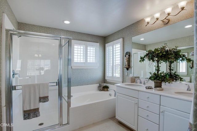 full bath featuring a sink, a garden tub, a shower stall, and wallpapered walls