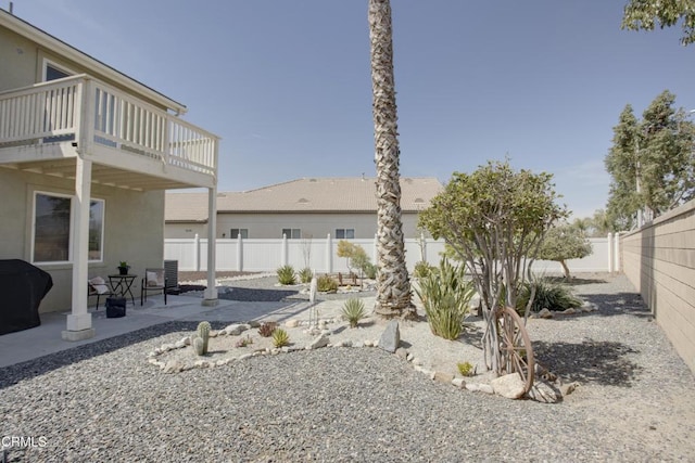 back of property with a balcony, central AC unit, a fenced backyard, stucco siding, and a patio area
