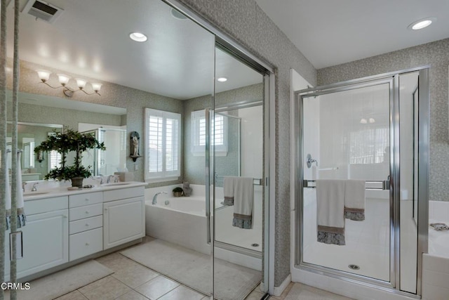 bathroom featuring a sink, a shower stall, a bath, visible vents, and double vanity