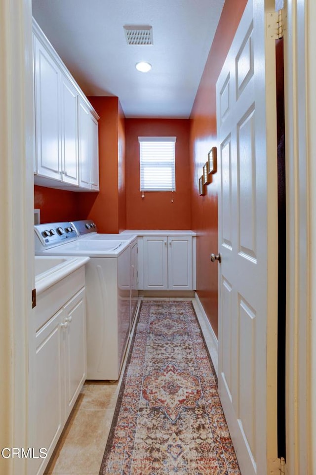 washroom with washing machine and clothes dryer, light tile patterned flooring, cabinet space, and visible vents