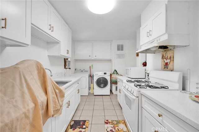 929 E Elizabeth St, Barstow, CA 92311 - kitchen featuring white appliances, washer and dryer, a sink, under cabinet range hood, and light tile patterned floors