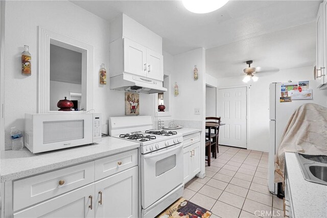 929 E Elizabeth St, Barstow, CA 92311 - kitchen featuring white appliances, under cabinet range hood, white cabinetry, light tile patterned floors, and a ceiling fan