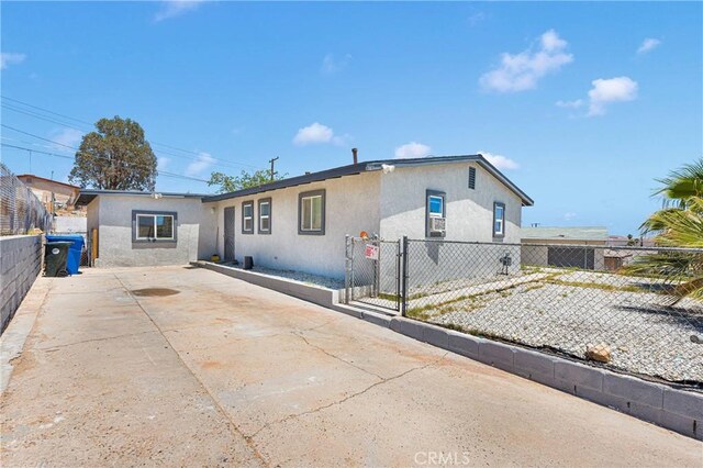 929 E Elizabeth St, Barstow, CA 92311 - view of front of house featuring stucco siding, driveway, and a gate