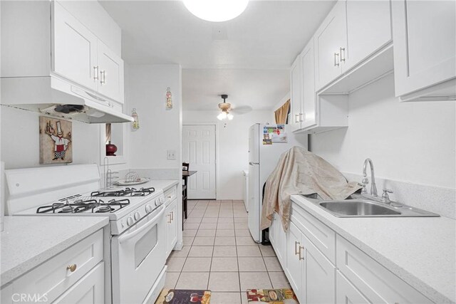 929 E Elizabeth St, Barstow, CA 92311 - kitchen with white appliances, a sink, light tile patterned floors, white cabinetry, and a ceiling fan