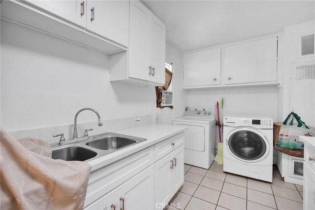 929 E Elizabeth St, Barstow, CA 92311 - laundry room featuring washer and dryer, cabinet space, and light tile patterned floors