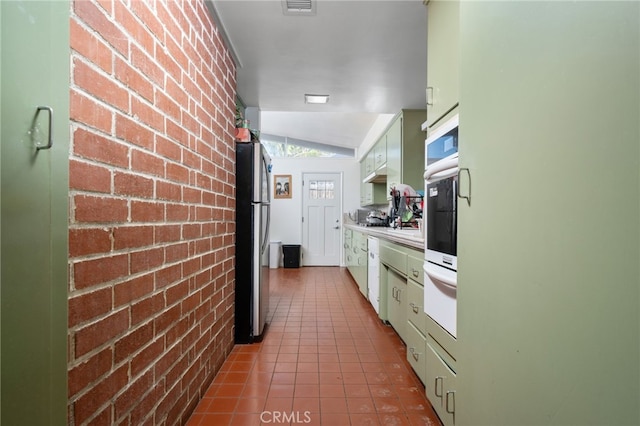 3540 Watkins Dr, Riverside, CA 92507 - kitchen with light countertops, a warming drawer, appliances with stainless steel finishes, tile patterned flooring, and brick wall