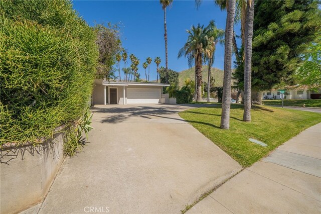 3540 Watkins Dr, Riverside, CA 92507 - view of front facade featuring driveway, an attached garage, a front lawn, and stucco siding