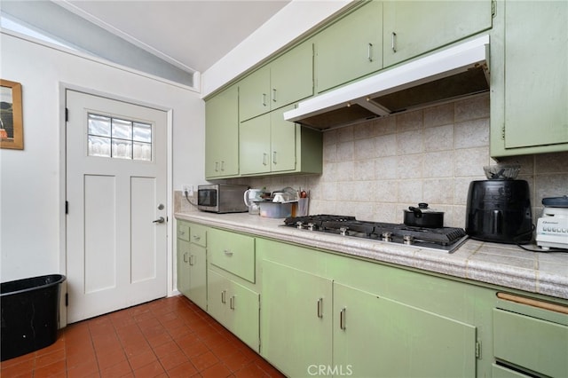 3540 Watkins Dr, Riverside, CA 92507 - kitchen with green cabinets, vaulted ceiling, under cabinet range hood, decorative backsplash, and appliances with stainless steel finishes