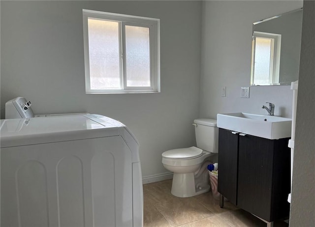 bathroom featuring vanity, toilet, and washer and dryer