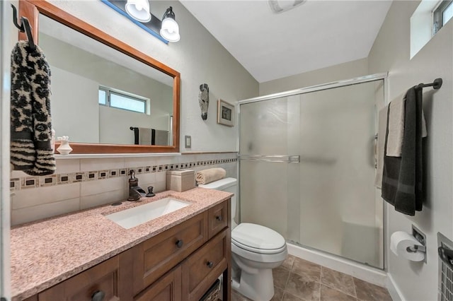 bathroom featuring vanity, toilet, tile walls, and a stall shower