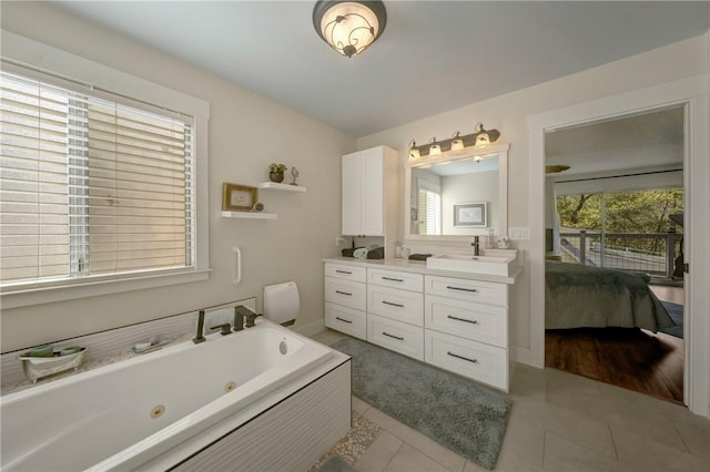 ensuite bathroom featuring a healthy amount of sunlight, vanity, a tub with jets, and ensuite bath