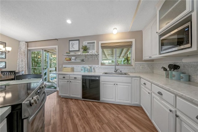 kitchen with a sink, light wood-style floors, dishwasher, a textured ceiling, and stainless steel microwave