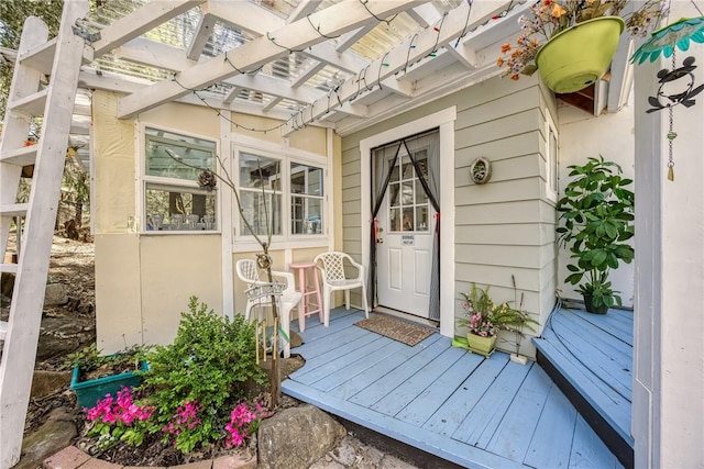 entrance to property with a pergola and a deck