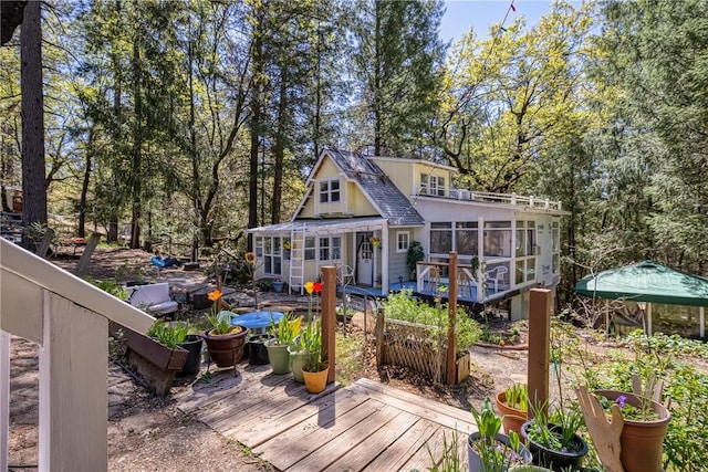 back of property with a sunroom and a deck