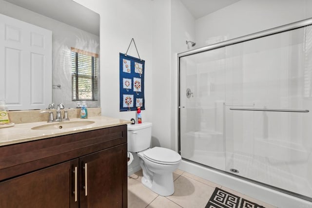 bathroom featuring tile patterned floors, toilet, a stall shower, and vanity
