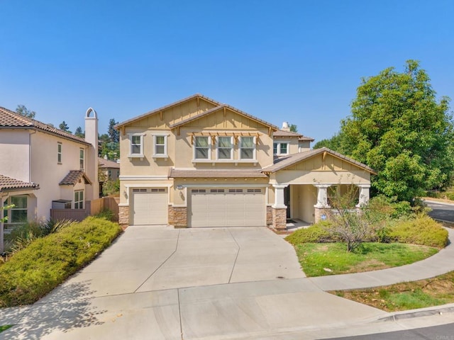 craftsman inspired home with stone siding, concrete driveway, stucco siding, fence, and a garage