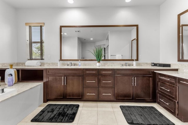 full bath featuring recessed lighting, double vanity, a sink, and tile patterned flooring