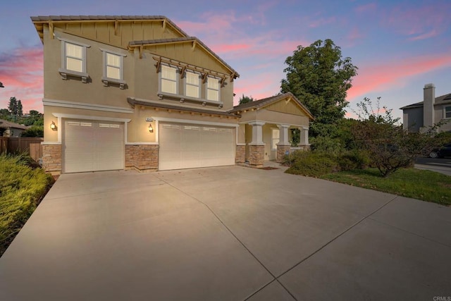 craftsman inspired home with stone siding, board and batten siding, concrete driveway, and a garage