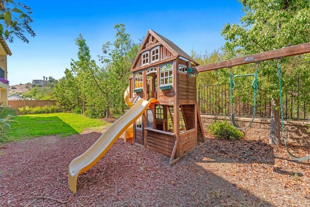 view of jungle gym with a yard and fence